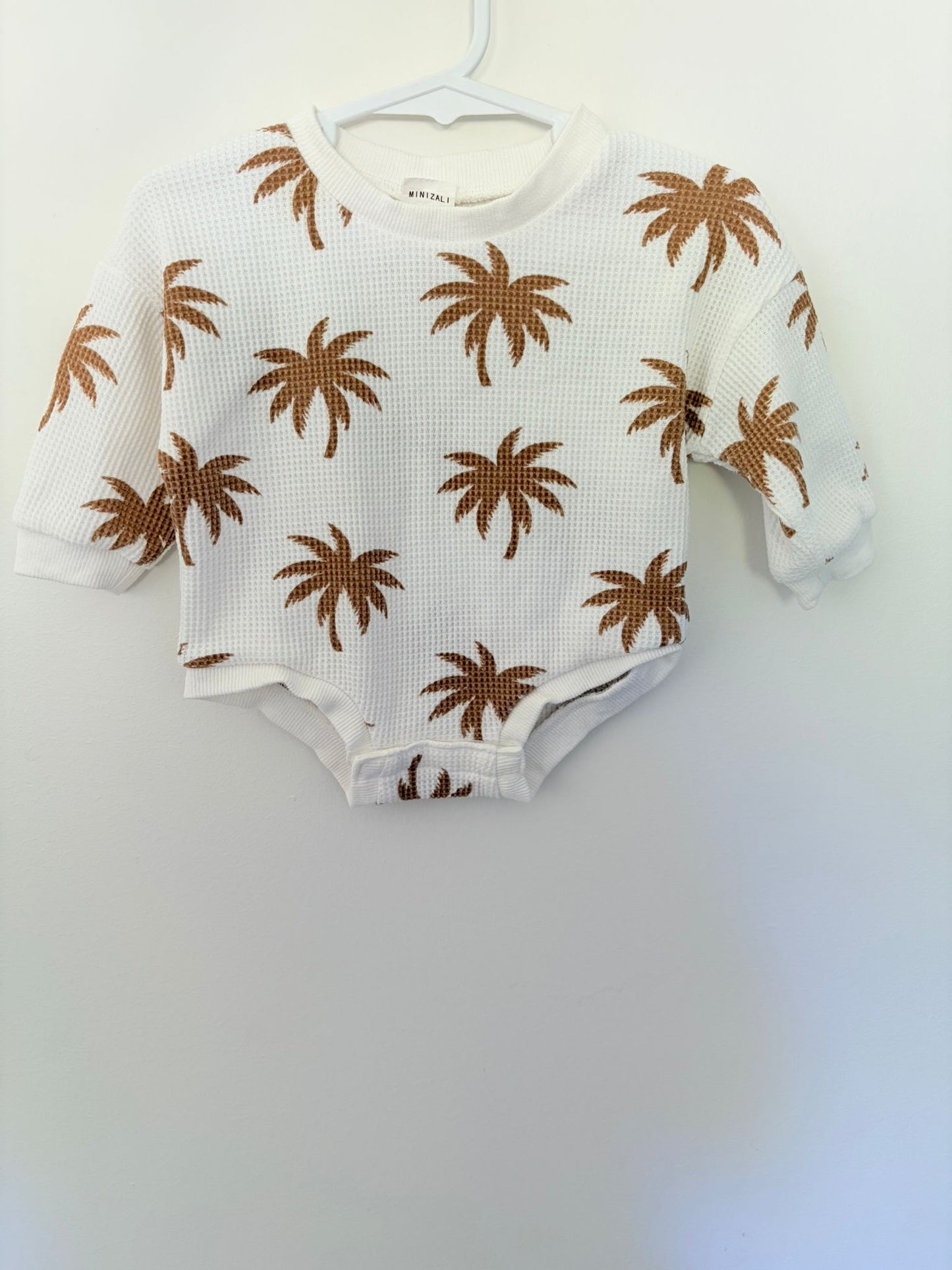 Size 000 Mini Zali white waffle long sleeve bodysuit with palm trees.