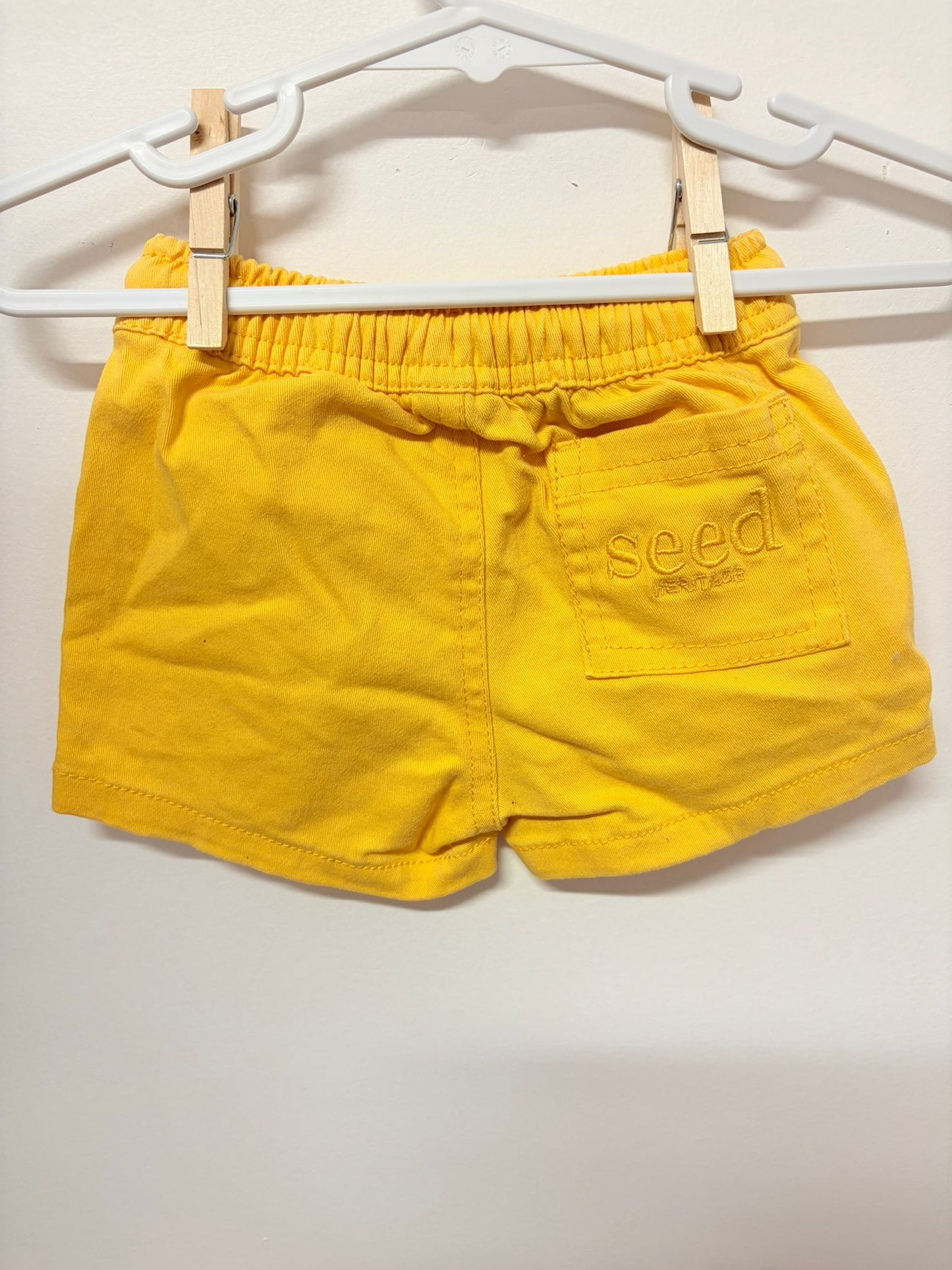 Size 000 Seed yellow shorts embroidered logo.